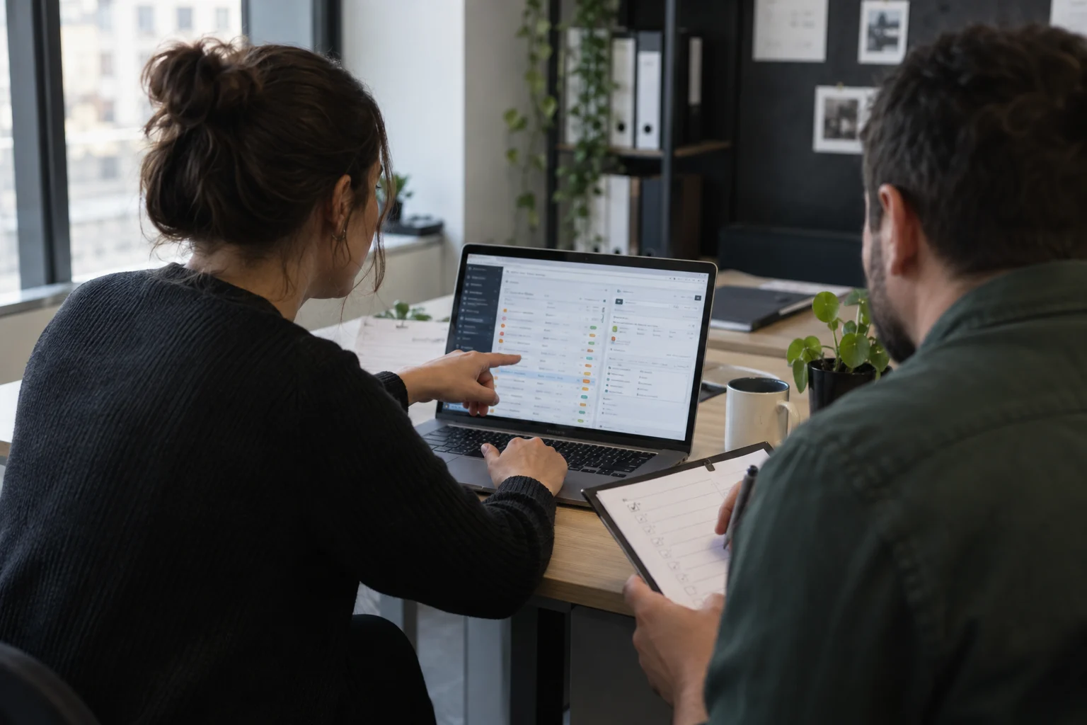 Two people evaluating a case-tracking software together on a computer, one using the interface and the other taking notes